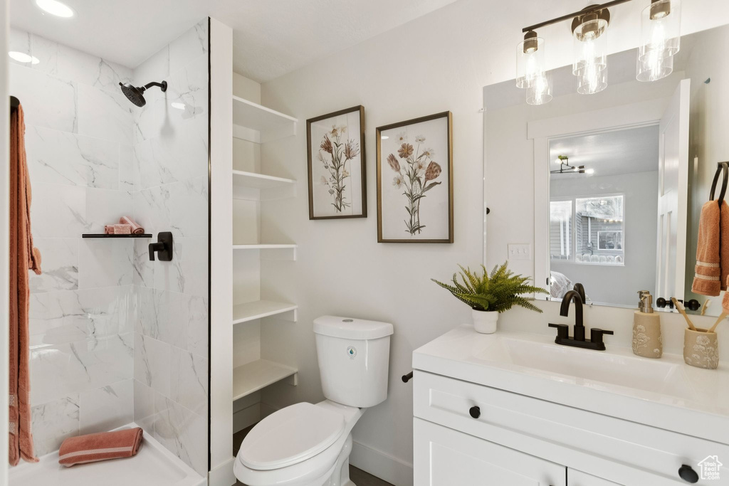 Bathroom featuring vanity, toilet, and a marble finish shower