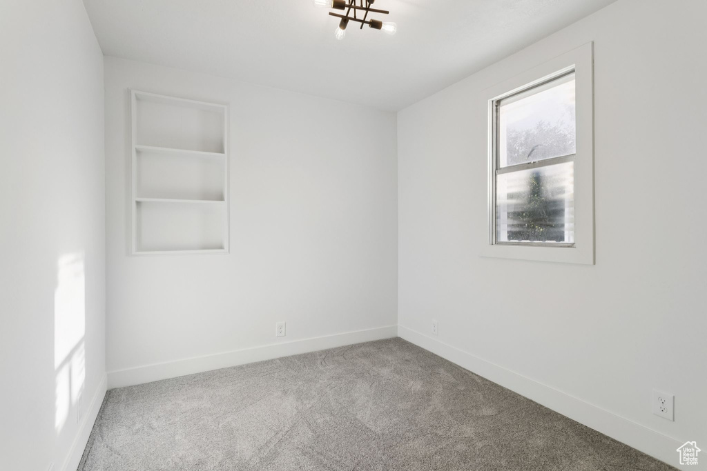 Spare room featuring carpet flooring and baseboards