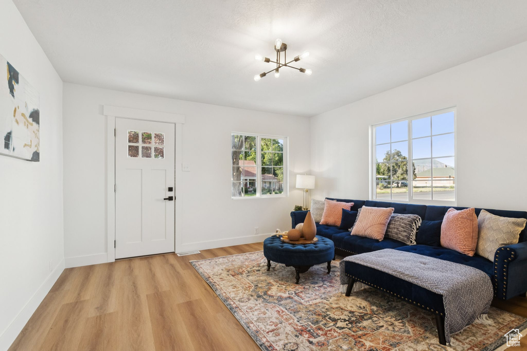 Living area with a chandelier, light wood finished floors, and baseboards