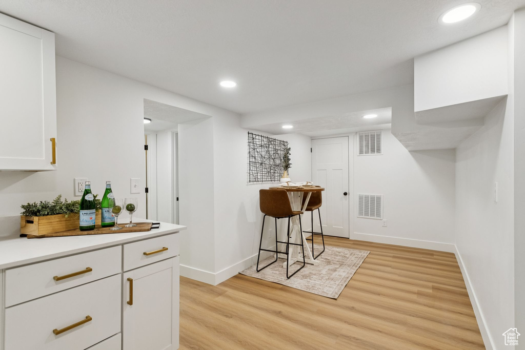 Bar area featuring light wood-style flooring, baseboards, and recessed lighting