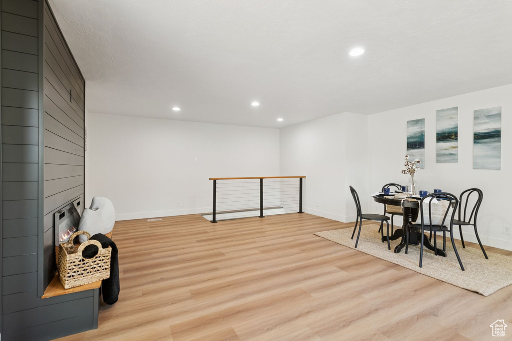 Dining area with light wood-style flooring, recessed lighting, baseboards, and a large fireplace