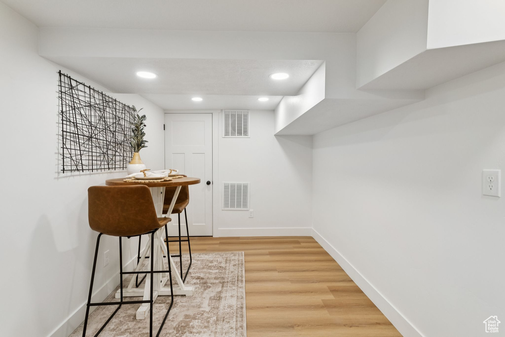 Bar area featuring light wood-style floors, baseboards, and recessed lighting