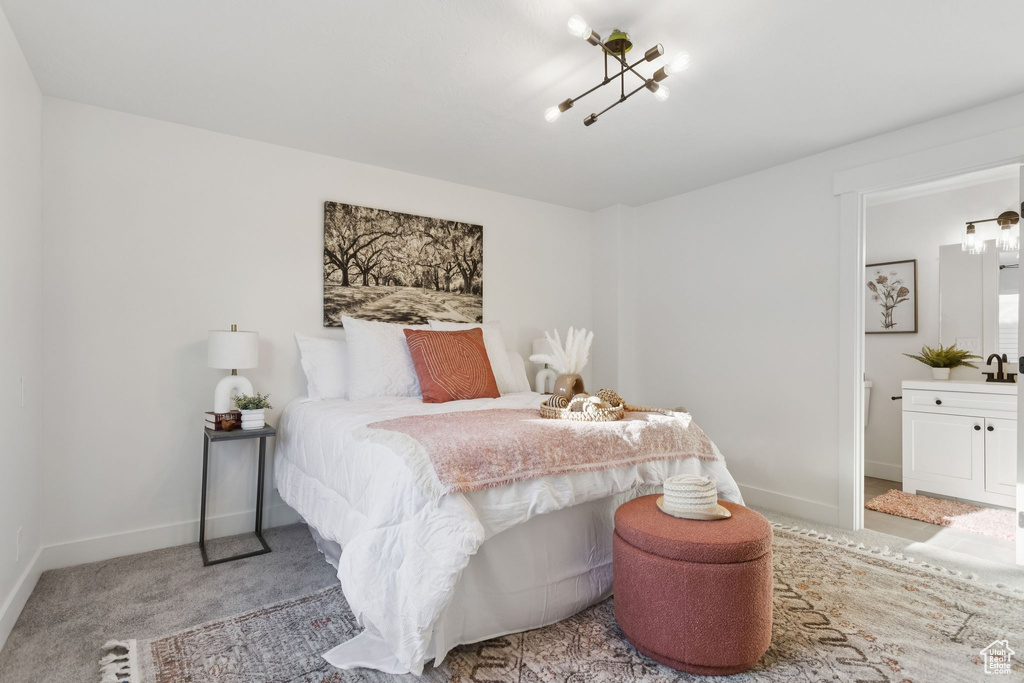 Carpeted bedroom with baseboards, a sink, and connected bathroom