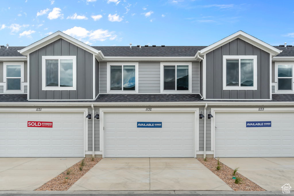 Multi unit property with board and batten siding, concrete driveway, and an attached garage