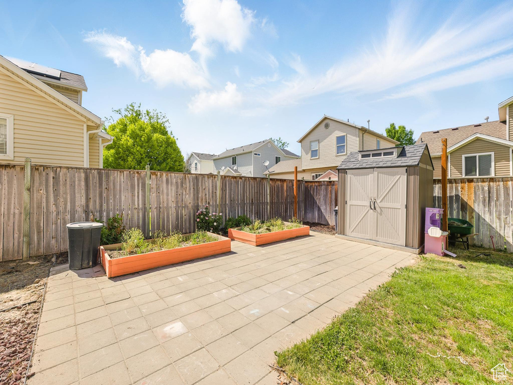 Fenced backyard featuring a garden, a residential view, and a patio