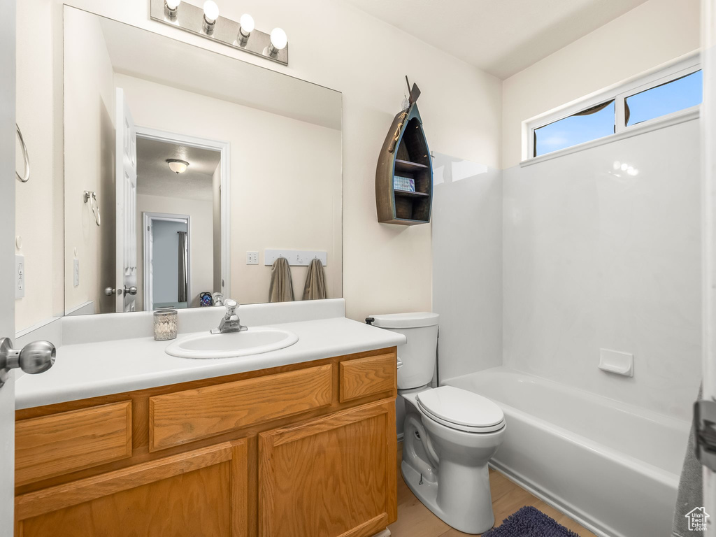 Bathroom with toilet, vanity, and bathing tub / shower combination