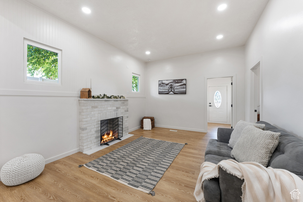 Living area featuring a fireplace, wood finished floors, recessed lighting, and baseboards