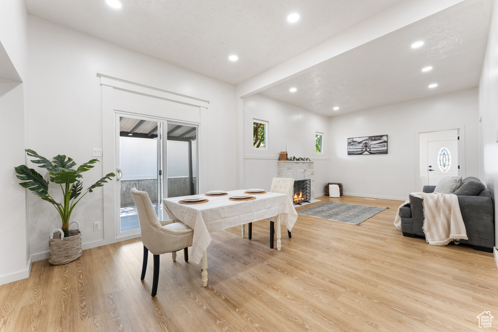 Dining space with recessed lighting, light wood finished floors, a fireplace, and baseboards