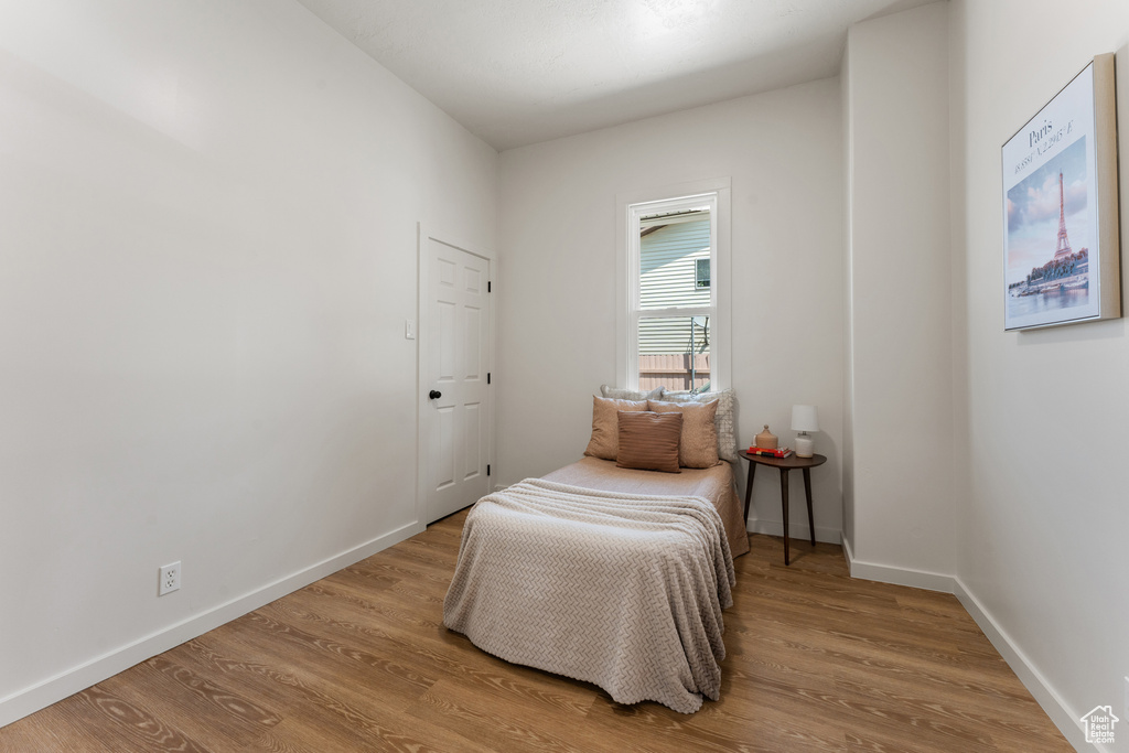 Bedroom with wood finished floors and baseboards