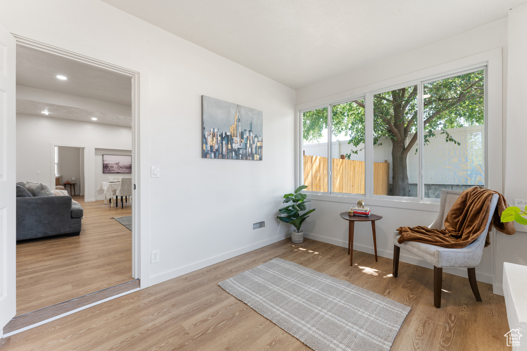 Living area with wood finished floors, baseboards, and recessed lighting