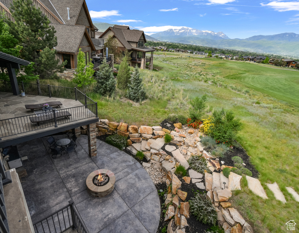 View of patio / terrace featuring an outdoor fire pit, a mountain view, and view of golf course