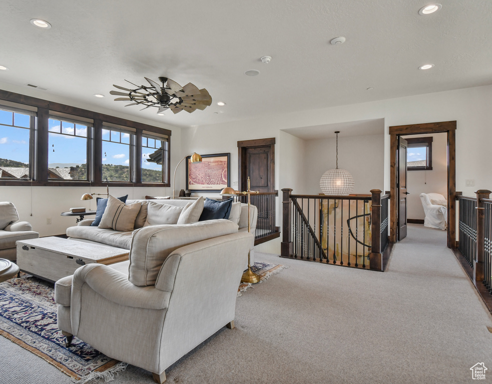 Living area featuring recessed lighting, light colored carpet, and a ceiling fan