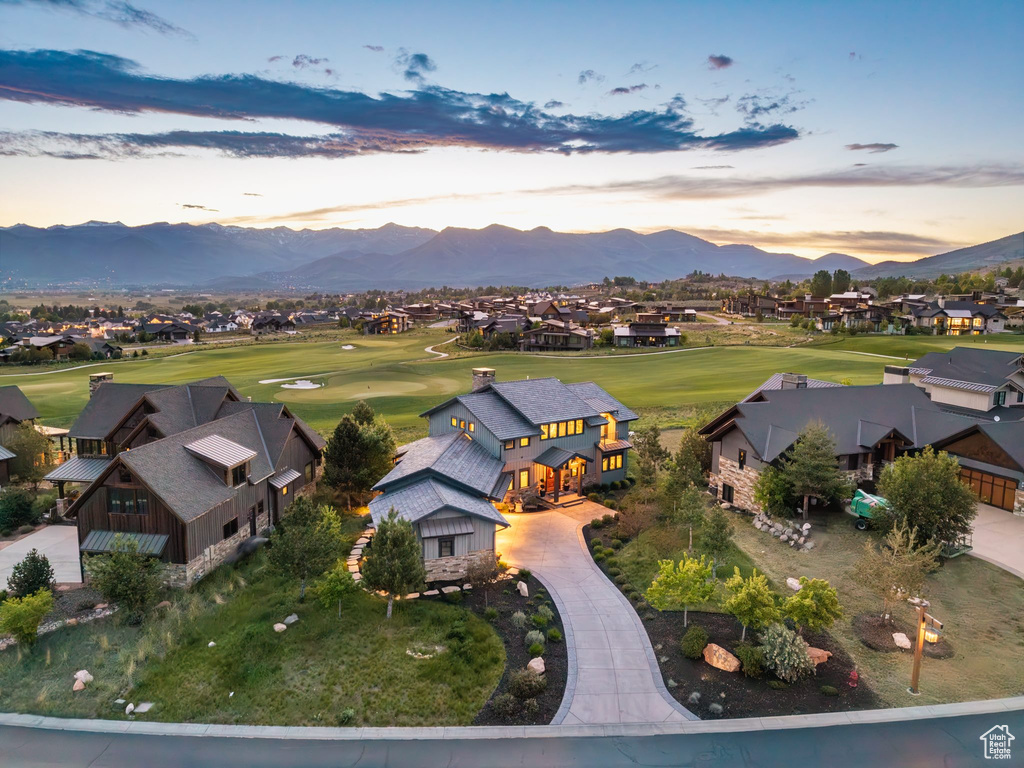 Aerial perspective of suburban area with a golf course and a mountain backdrop