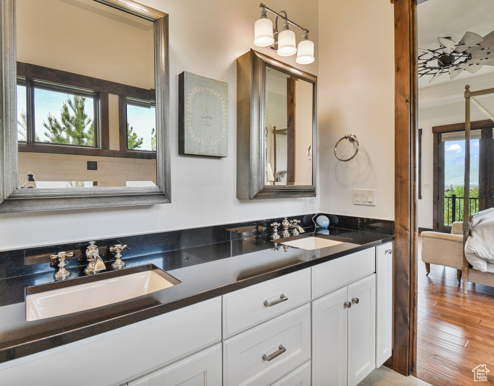 Ensuite bathroom with double vanity and wood finished floors