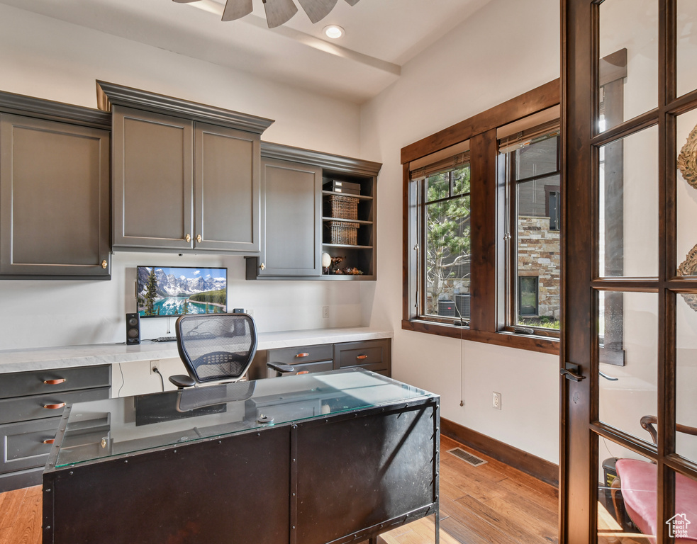Kitchen featuring light wood finished floors, a ceiling fan, baseboards, light stone counters, and open shelves
