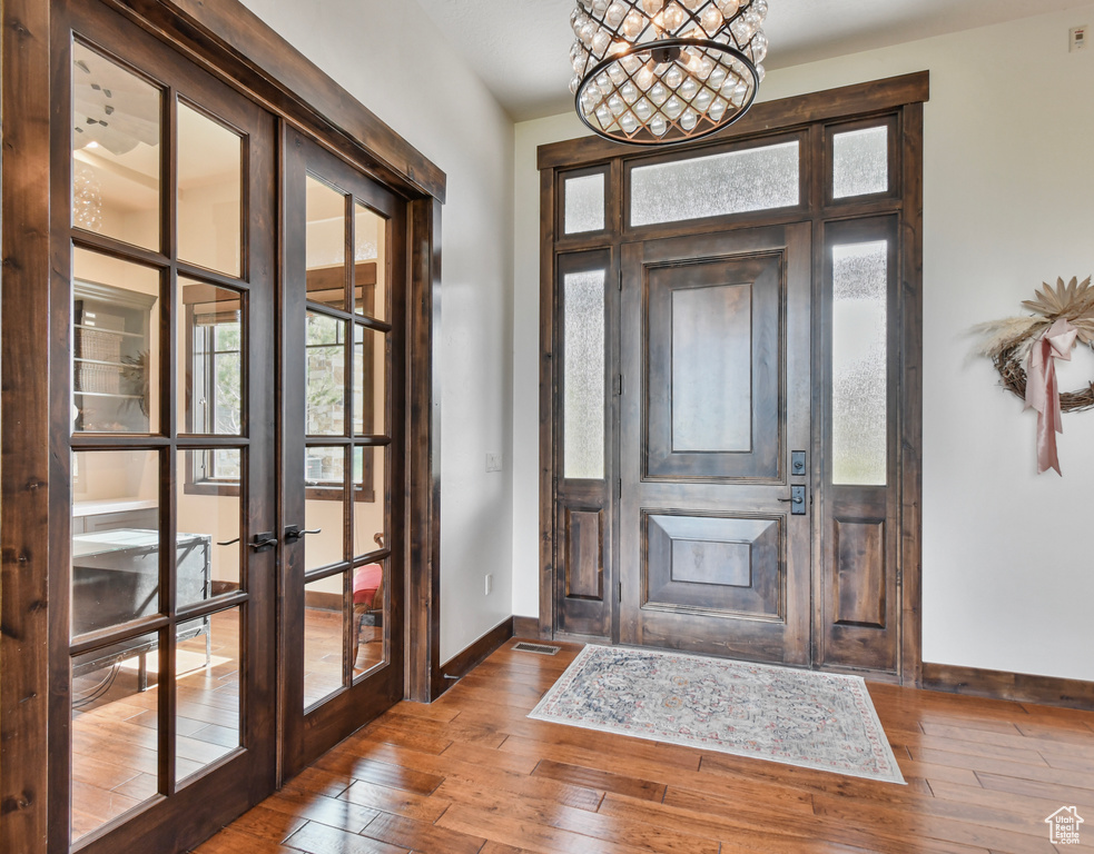 Entryway with french doors, baseboards, wood-type flooring, and plenty of natural light