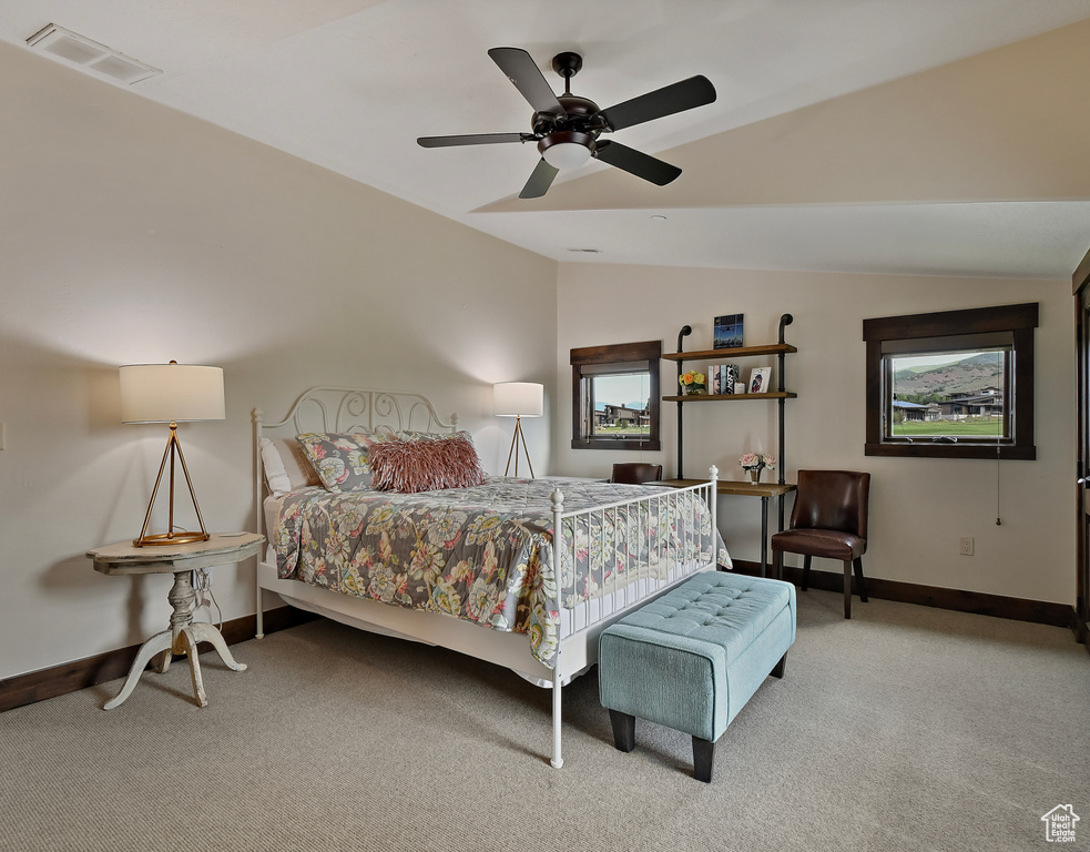Bedroom with lofted ceiling, light carpet, baseboards, and ceiling fan