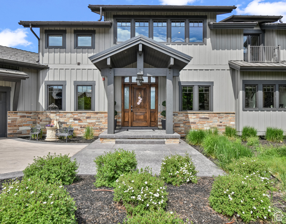 Doorway to property with stone siding and board and batten siding