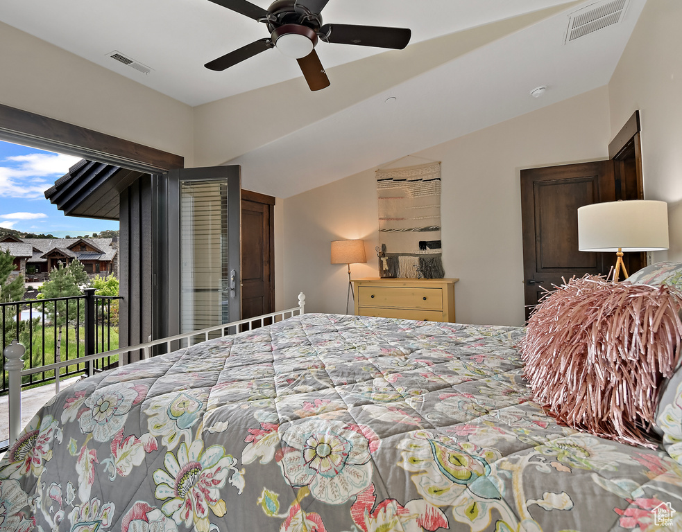 Bedroom featuring access to exterior, vaulted ceiling, and a ceiling fan