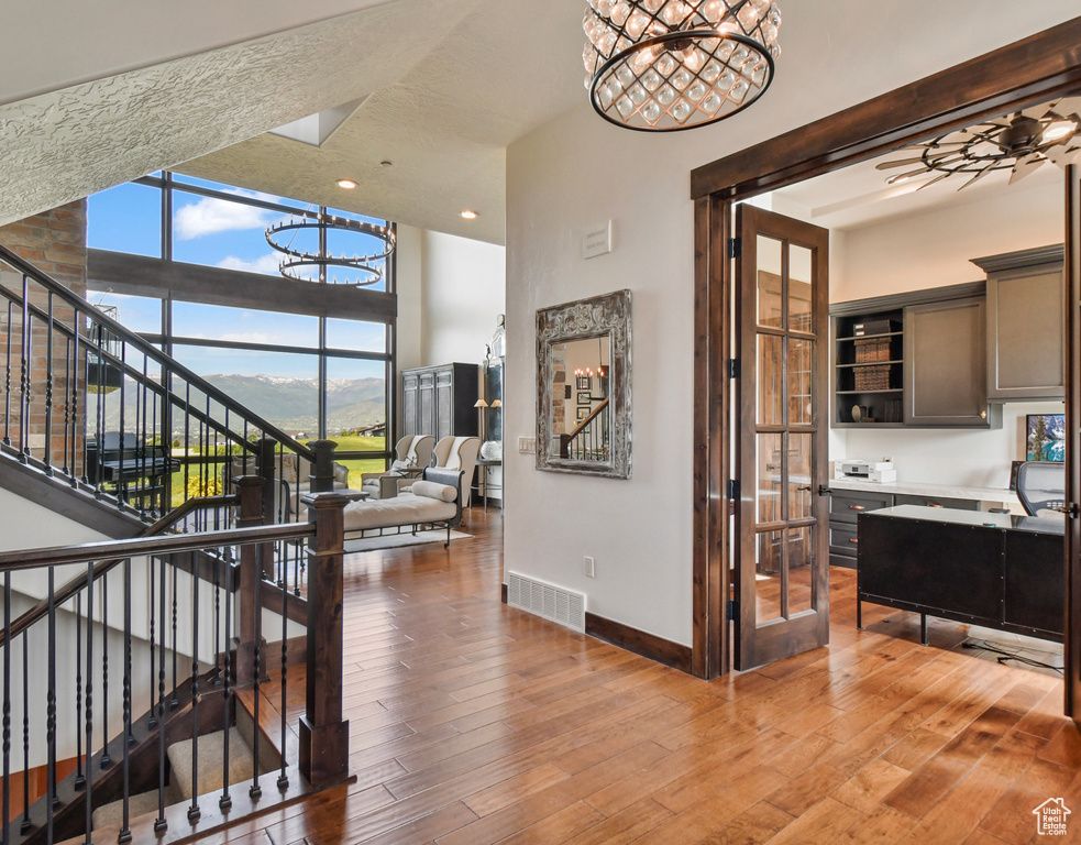 Corridor featuring a chandelier, baseboards, stairs, hardwood / wood-style floors, and recessed lighting