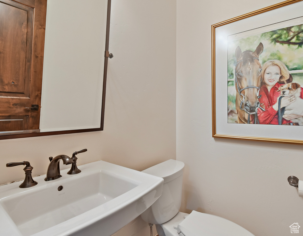 Half bathroom featuring a sink and toilet