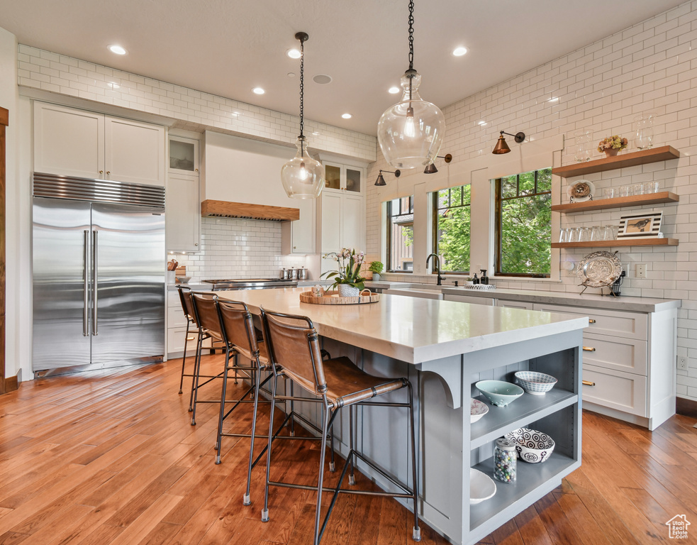 Kitchen with open shelves, stainless steel appliances, light countertops, white cabinets, and recessed lighting