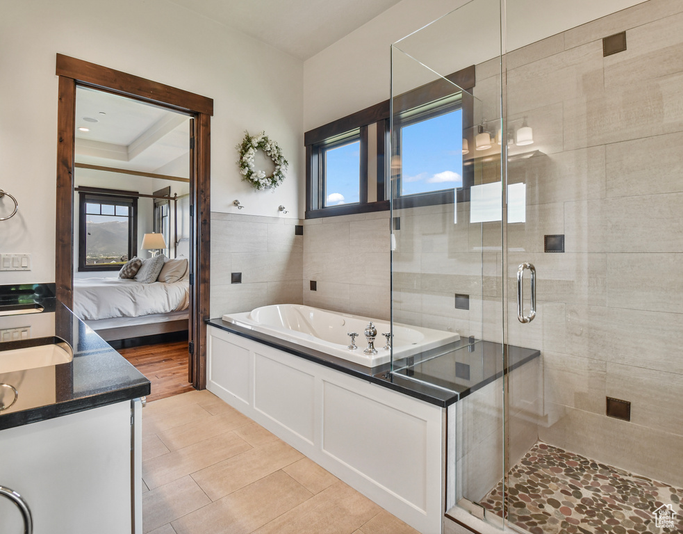 Full bath with a garden tub, ensuite bath, vanity, a shower stall, and tile patterned flooring