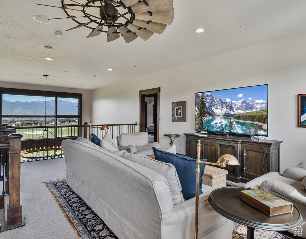 Carpeted living area with ceiling fan and recessed lighting
