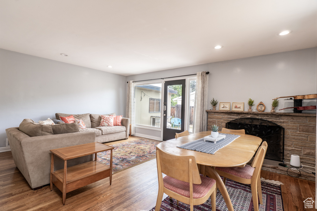 Dining space with wood finished floors, a fireplace, and recessed lighting