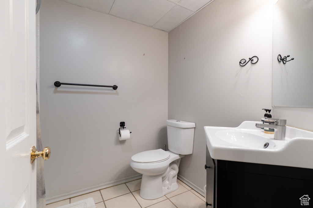 Bathroom with tile patterned flooring, toilet, vanity, and baseboards