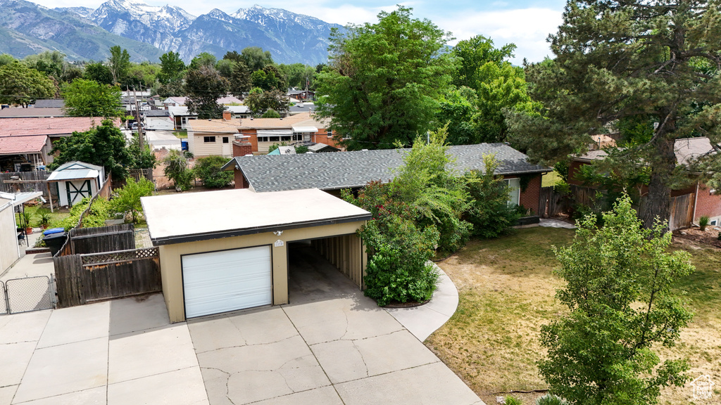 View of front of home with concrete driveway, a residential view, and a mountain view
