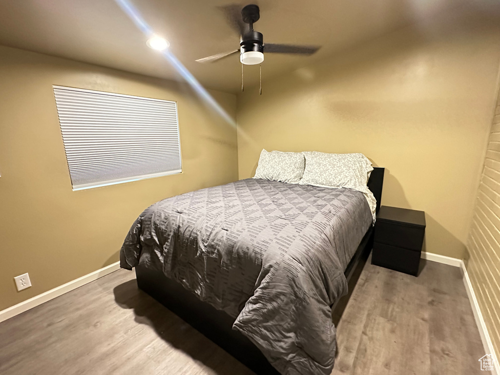 Bedroom with wood finished floors, baseboards, and ceiling fan