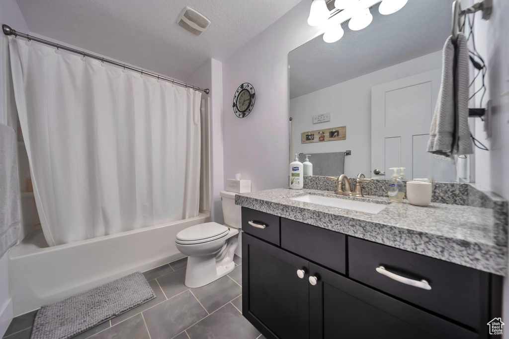 Bathroom featuring vanity, shower / bathtub combination with curtain, and tile patterned floors