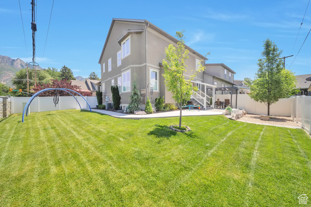 Back of property with stucco siding, a fenced backyard, and a patio