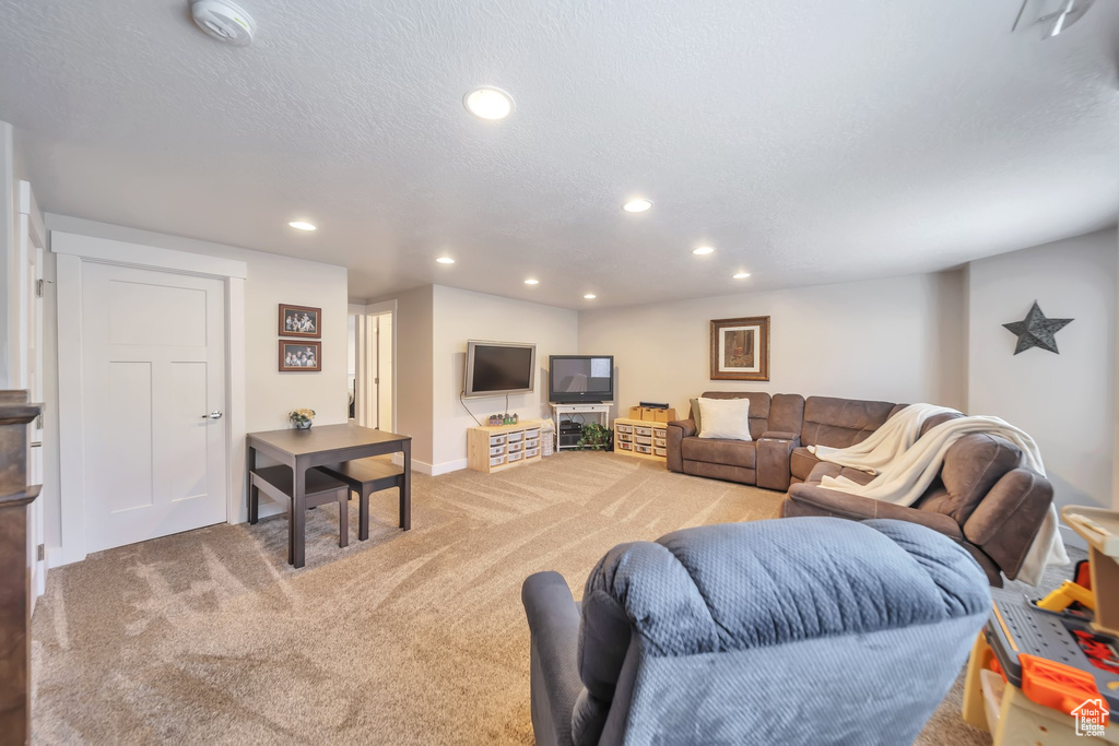 Living area with light colored carpet and recessed lighting