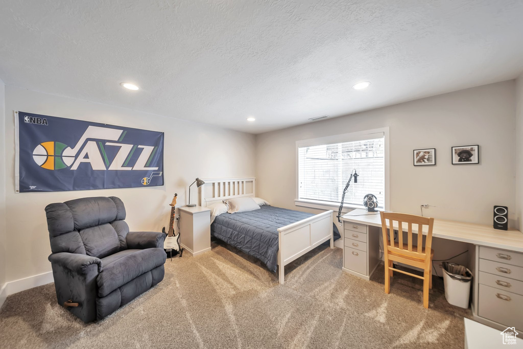 Carpeted bedroom featuring recessed lighting, a desk, and a textured ceiling