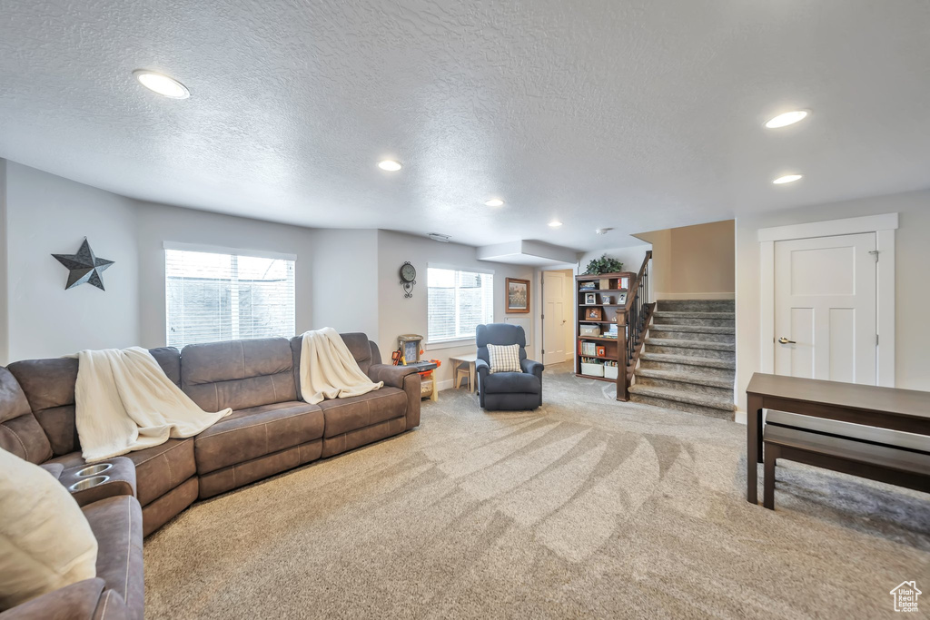 Carpeted living area featuring recessed lighting, a textured ceiling, stairway, and plenty of natural light