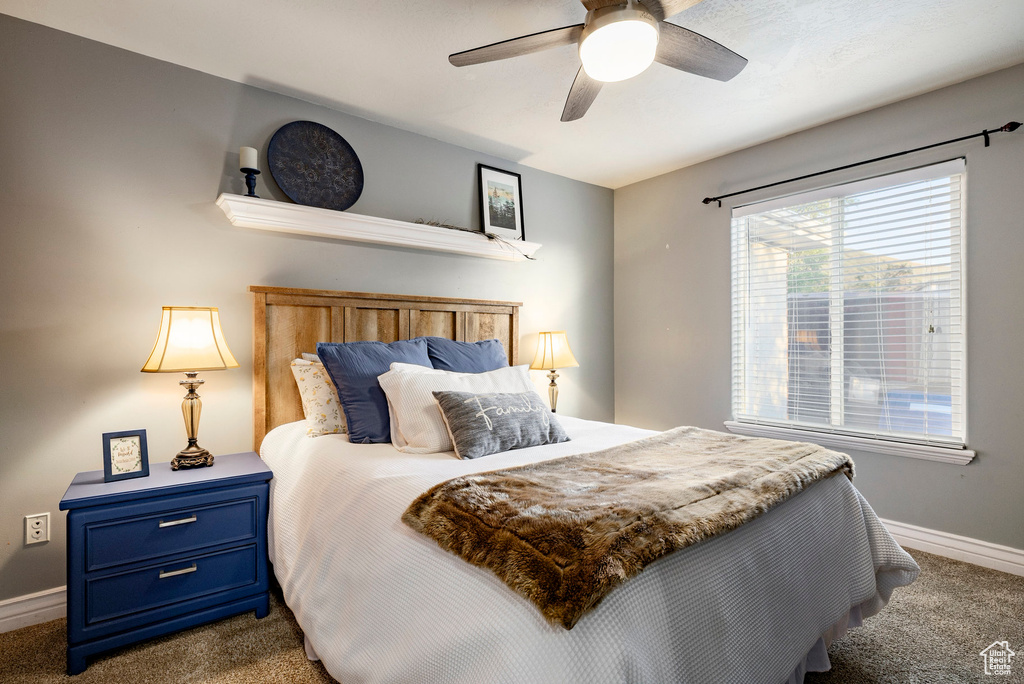 Carpeted bedroom with baseboards and a ceiling fan