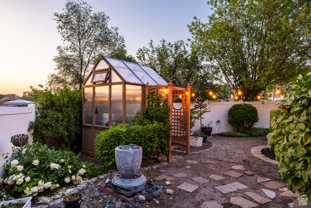Fenced backyard featuring an exterior structure and an outbuilding