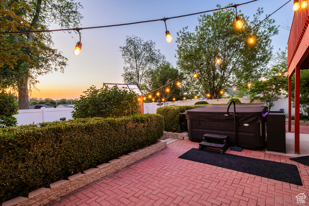 Fenced backyard featuring a hot tub and a patio area