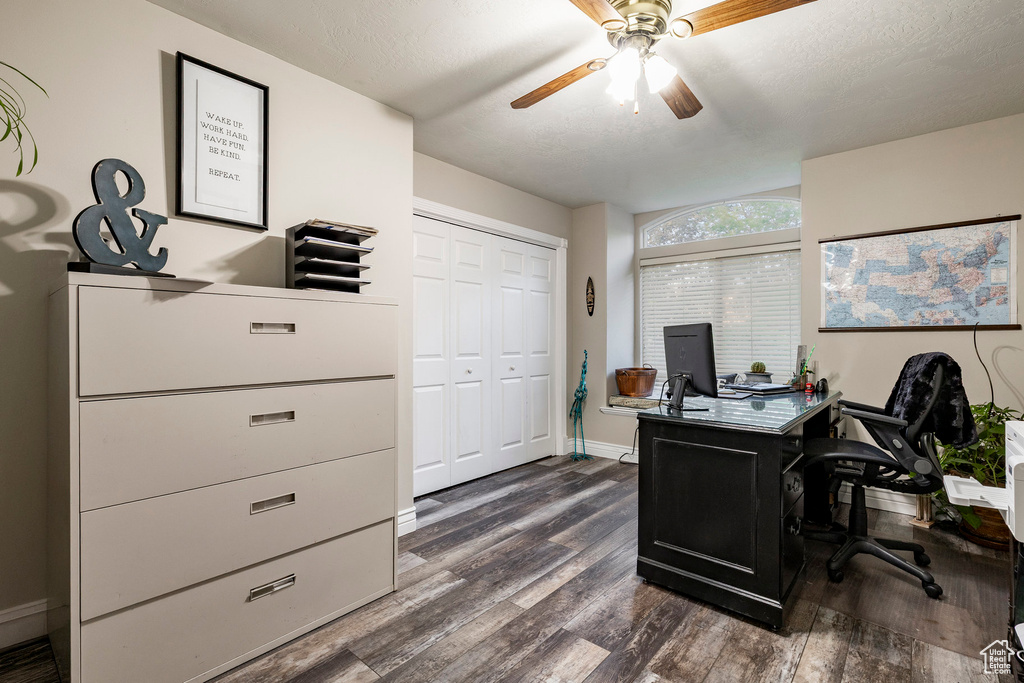 Office area featuring dark wood-style floors, ceiling fan, and baseboards