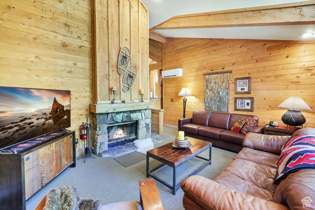 Carpeted living room featuring wood walls and a fireplace