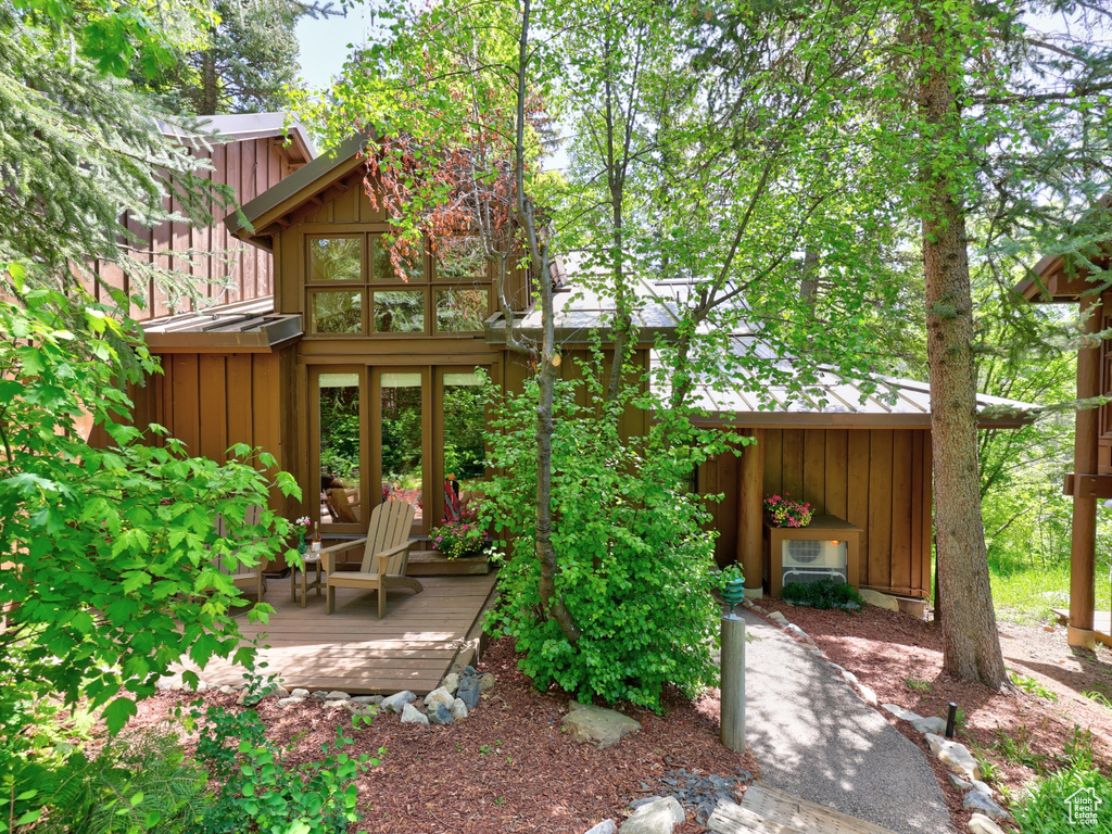 Back of property with board and batten siding and a deck