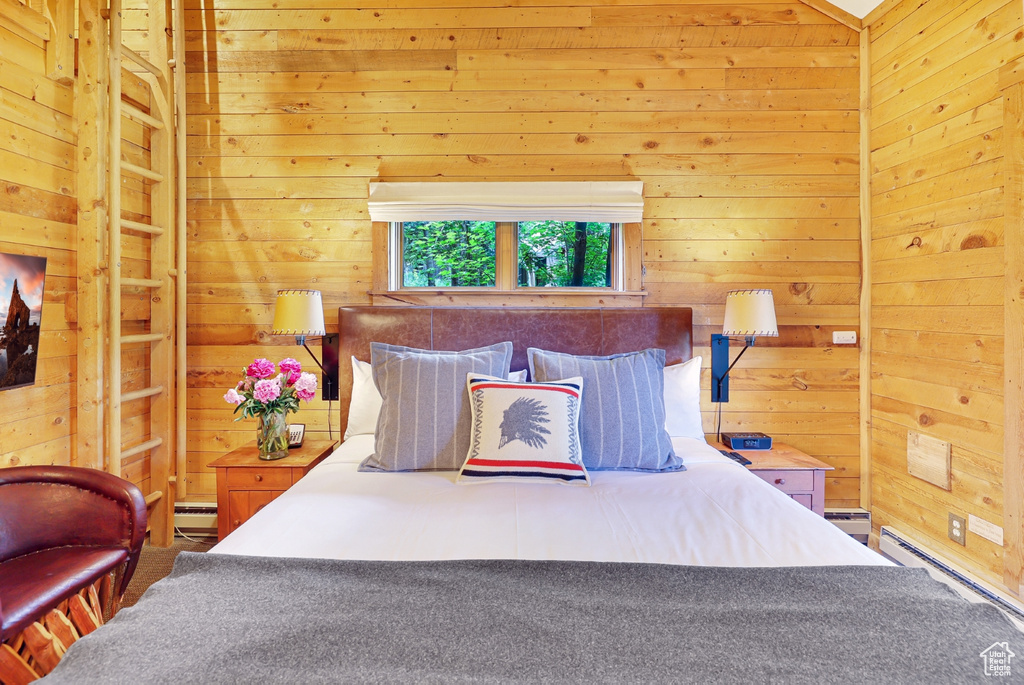 Bedroom with wooden walls and a baseboard radiator