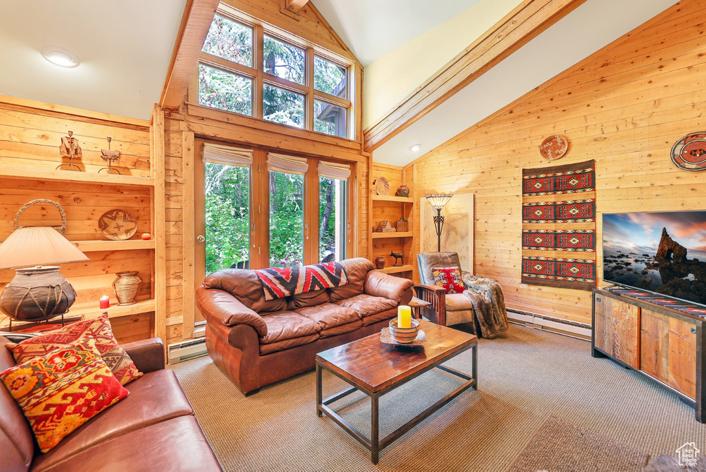 Living room featuring wood walls, high vaulted ceiling, carpet floors, and baseboard heating