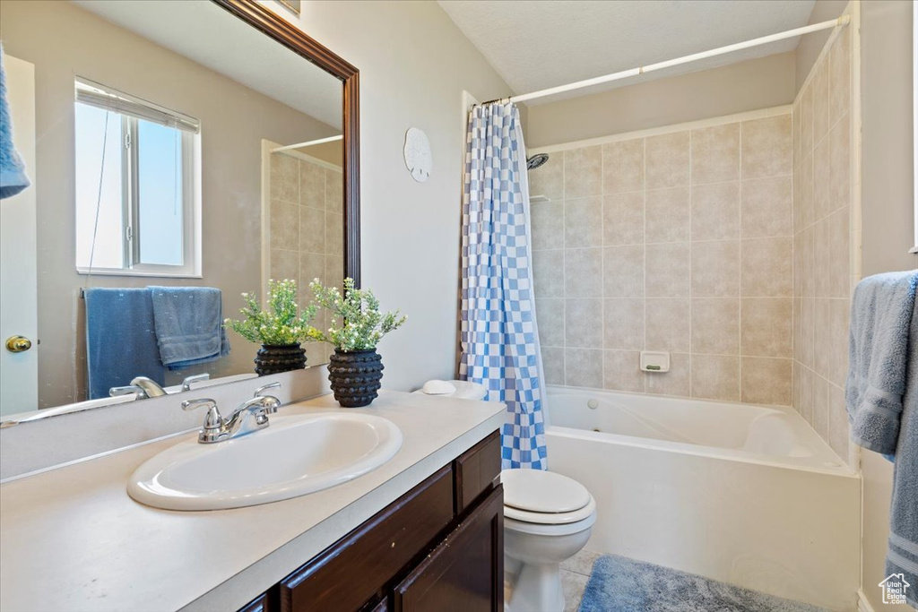 Full bath featuring vanity, toilet, and shower / bath combo