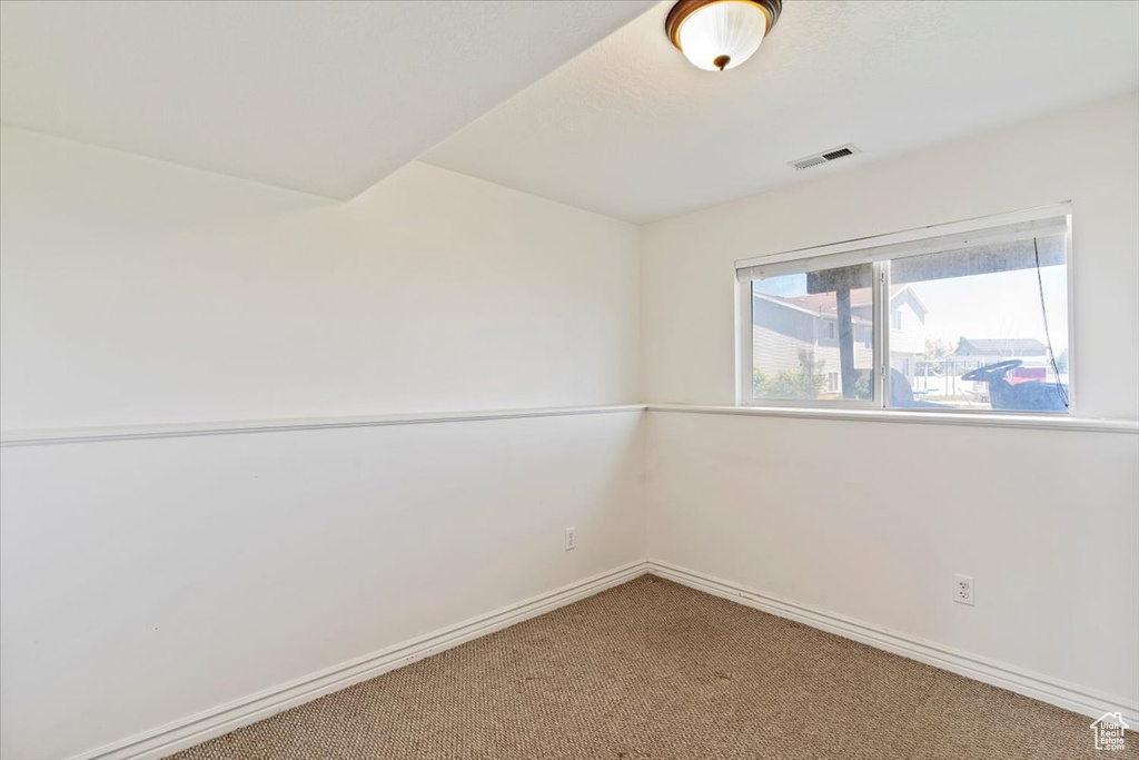 Spare room featuring carpet and baseboards