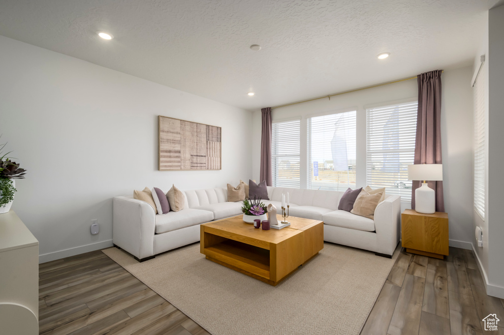 Living room with light wood-style flooring, recessed lighting, and baseboards