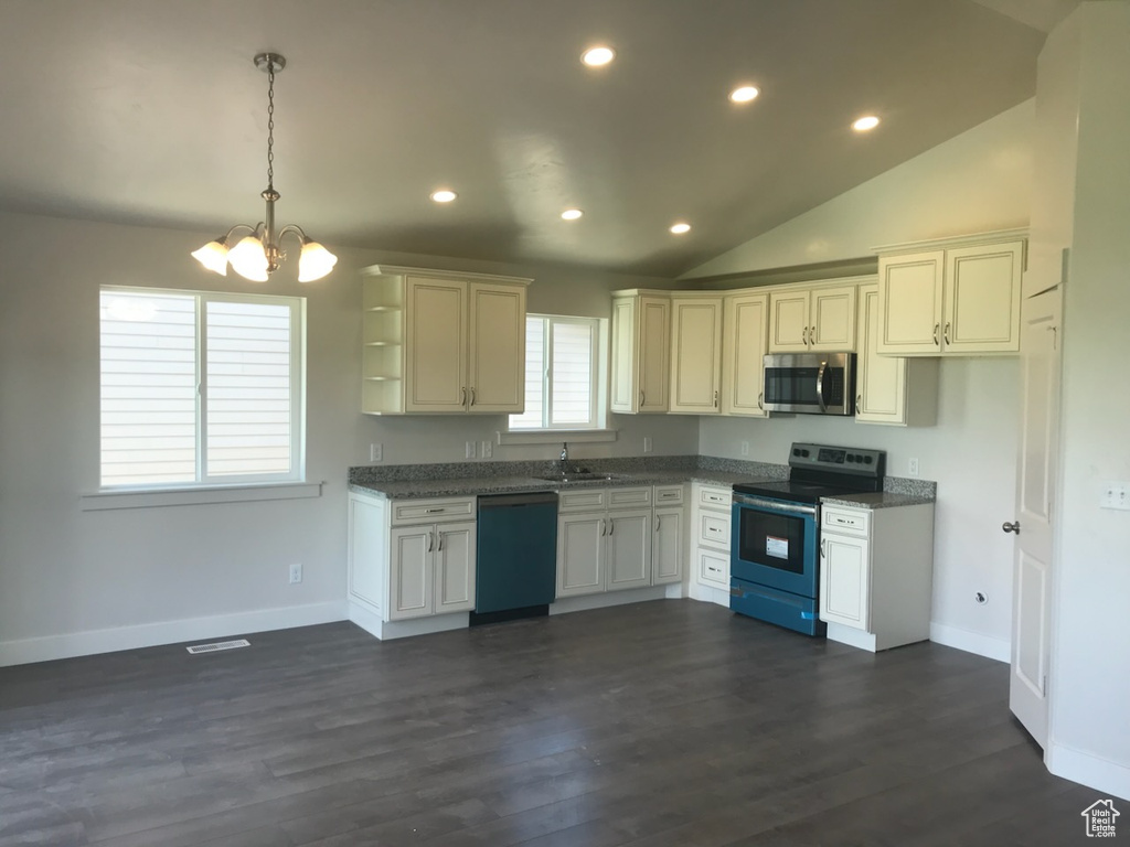 Kitchen with appliances with stainless steel finishes, a sink, a chandelier, baseboards, and recessed lighting
