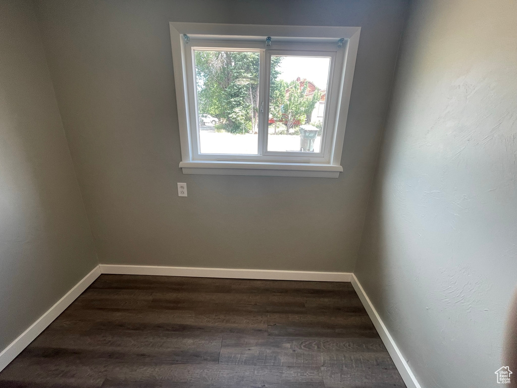 Unfurnished room with dark wood-style flooring and baseboards